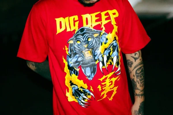 claws1 Model with a visible tattoo, wearing casual clothing, posing naturally, highlighting streetwear style.